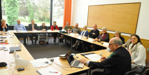 Die Gruppe sitzt an einem Tisch-Karree mit Francois Brunagel am Laptop